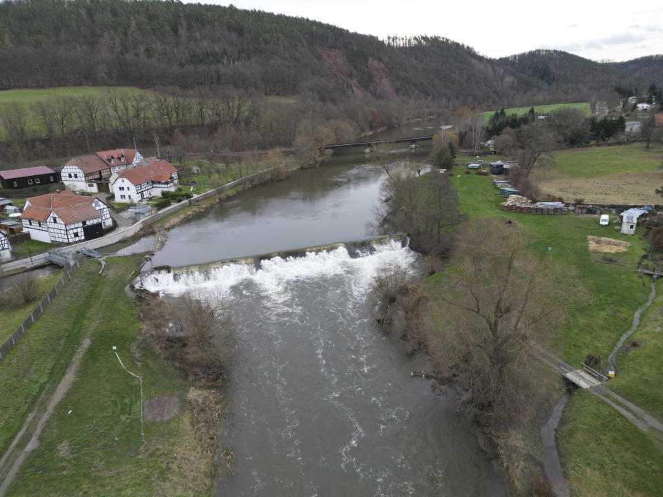 The waters of the Weiße Elster river rise as they pass near Wünschendorf, Germany, Thursday Dec. 28, 2023. (Bodo Schackow/dpa via AP)