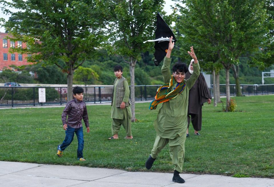 Aug 7, 2023; Buffalo, NY, USA Mohammad Shams, 14, second from right, runs with a kite that he found stuck in a tree, alongside his brothers and father at Broderick Park in Buffalo, N.Y., Tuesday, August 7, 2023. From left his brothers are, Mustafa Shams, 8, and Irshad Shams, 12, and Shams father is Mohammad Hakim Hotak, 68. Mohammed, 14, arrived alone to the USA in November 2021, just two months after the fall of Kabul. He didn't speak English and had no other relatives with him. At the two-year anniversary of the U.S.'s hasty retreat from Afghanistan, authorities continue to struggle with what to do with the remaining Afghan youths in U.S. custody.