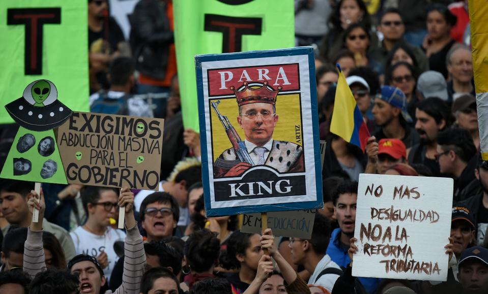A demonstrator holds a banner depicting Colombian ex-president Alvaro Uribe during a protest against a tax reform currently being discussed in the country, outside the Congress in Bogota on December 16, 2019. - The government of Colombian President Ivan Duque has been facing protests against his economic policies, unemployment, political corruption and drug-financed violence. (Photo by Juan BARRETO / AFP) (Photo by JUAN BARRETO/AFP via Getty Images)