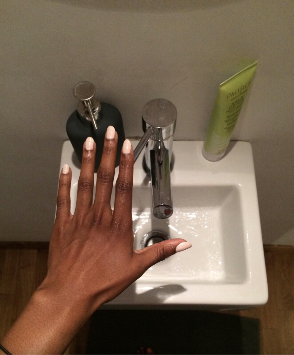 A person's hand over a small sink