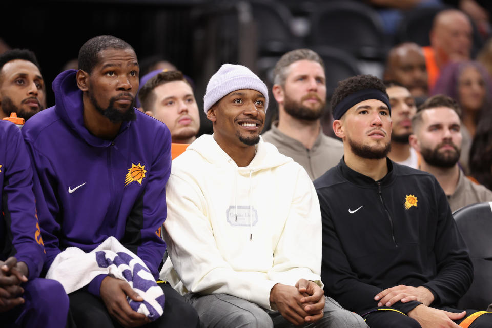 PHOENIX, ARIZONA - NOVEMBER 15: (L-R) Kevin Durant #35, Bradley Beal #3 and Devin Booker #1 of the Phoenix Suns watch from the bench during the second half of the NBA game against the Minnesota Timberwolves at Footprint Center on November 15, 2023 in Phoenix, Arizona. The Suns defeated the Timberwolves 133-115. NOTE TO USER: User expressly acknowledges and agrees that, by downloading and or using this photograph, User is consenting to the terms and conditions of the Getty Images License Agreement.  (Photo by Christian Petersen/Getty Images)