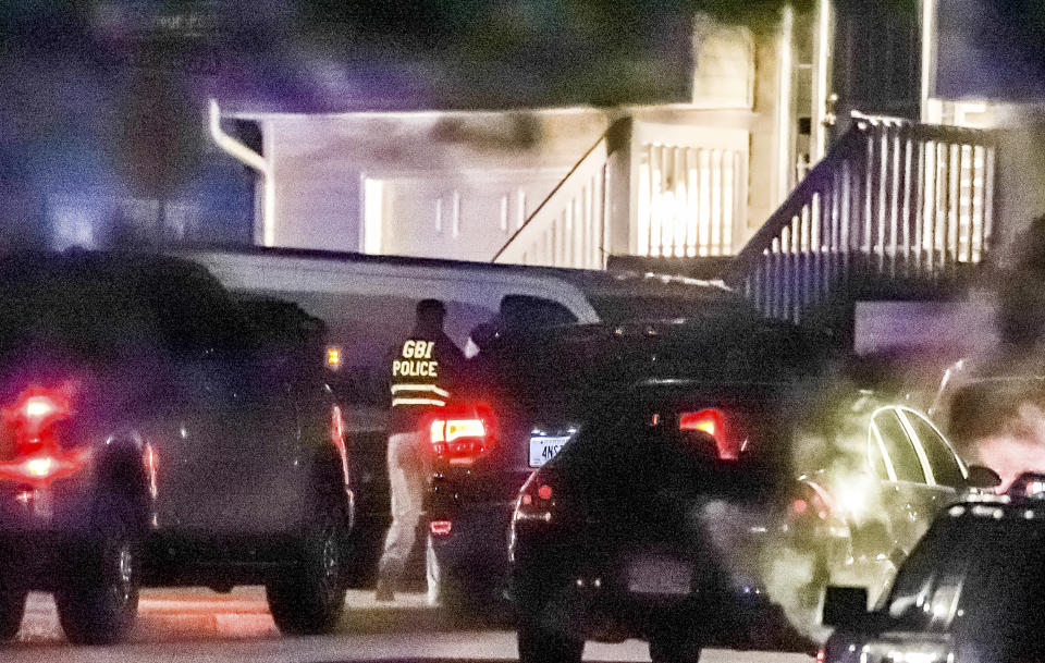 GBI agents and Clayton County police officers continue their investigation Wednesday, Dec. 1, 2021, into a shooting that occurred in Clayton County, south of Atlanta. Four people are dead, including a police officer, after officers responded to a domestic disturbance call Tuesday. (John Spink /Atlanta Journal-Constitution via AP)