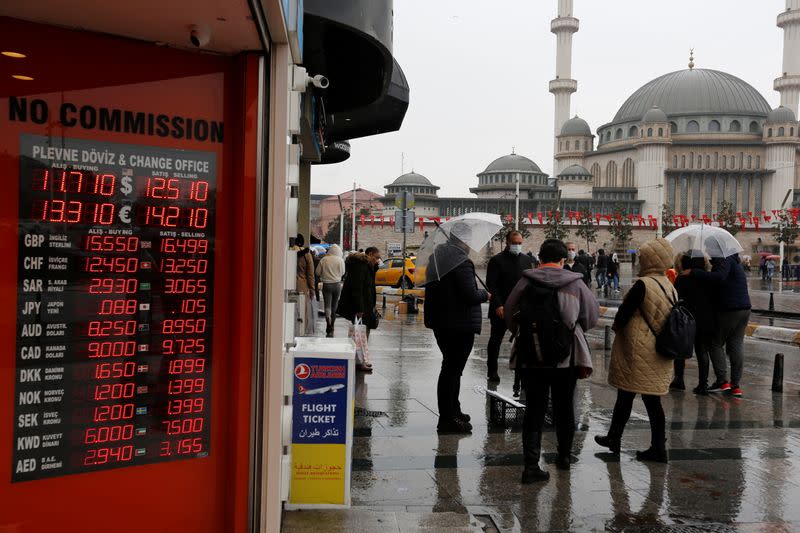 People stand outside a currency exchange office in Istanbul