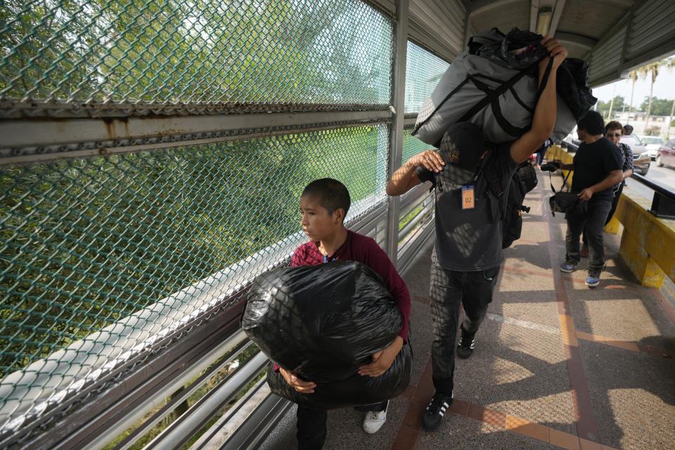 Migrants from a group of 50, chosen by the Casa Migrante organization, walk across the Puerto Nuevo bridge from Matamoros, Mexico, to be processed by U.S. immigration officials, early Friday, May 12, 2023, the day after pandemic-related asylum restrictions called Title 42 were lifted. According to Mexican immigration officials, migrants will be organized to cross in groups of 50. (AP Photo/Fernando Llano)