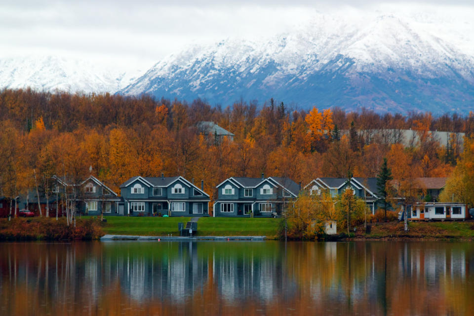 Houses tucked in front of a snowy mountain