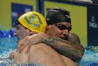 Caeleb Dressel hugs Zach Apple after winning the men's 100 freestyle during wave 2 of the U.S. Olympic Swim Trials on Thursday, June 17, 2021, in Omaha, Neb. (AP Photo/Charlie Neibergall)