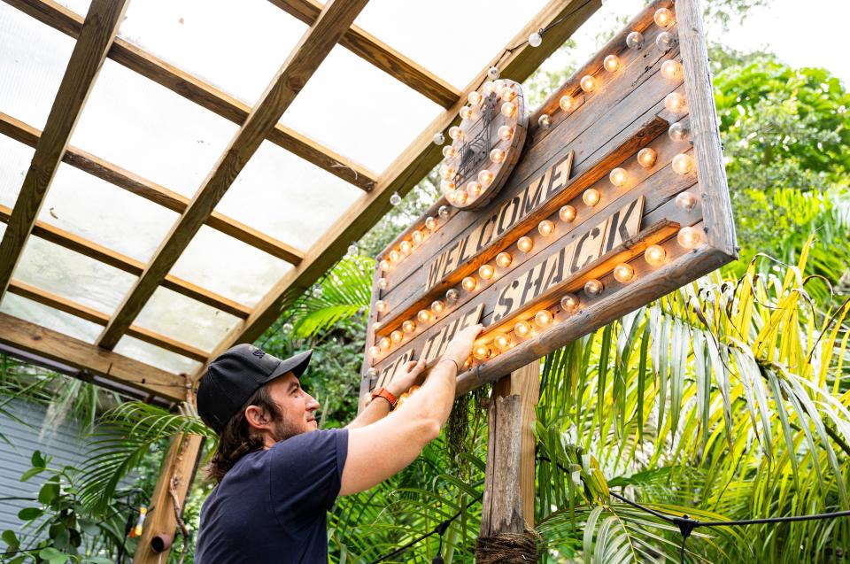 Co-founder Eddie Kopp sets up a sign at the Sugarshack in Bonita Springs on Thursday, July 27, 2023.