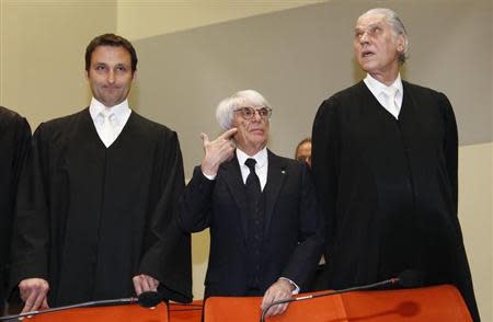 Formula One chief executive Bernie Ecclestone (C) stands with his lawyers Sven Thomas (R) and Norbert Scharf (L) as he arrives in court in Munich April 24, 2014. REUTERS/Michaela Rehle