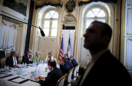 An Iranian security guard stands as U.S. Secretary of State John Kerry (2nd R) meets with the Iranian delegation including Iranian Foreign Minister Mohammad Javad Zarif at a hotel where the Iran nuclear talks meetings are being held in Vienna, Austria July 2, 2015. REUTERS/Carlos Barria