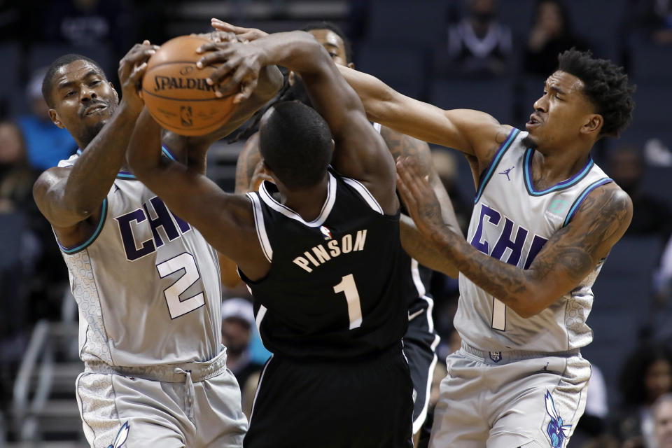 Charlotte Hornets' Marvin Williams (2) teams up with Malik Monk (1) to steal the ball away from Brooklyn Nets' Theo Pinson (1) during the second half of an NBA basketball game in Charlotte, N.C., Friday, Dec. 6, 2019. The Nets won 111-104. (AP Photo/Bob Leverone)