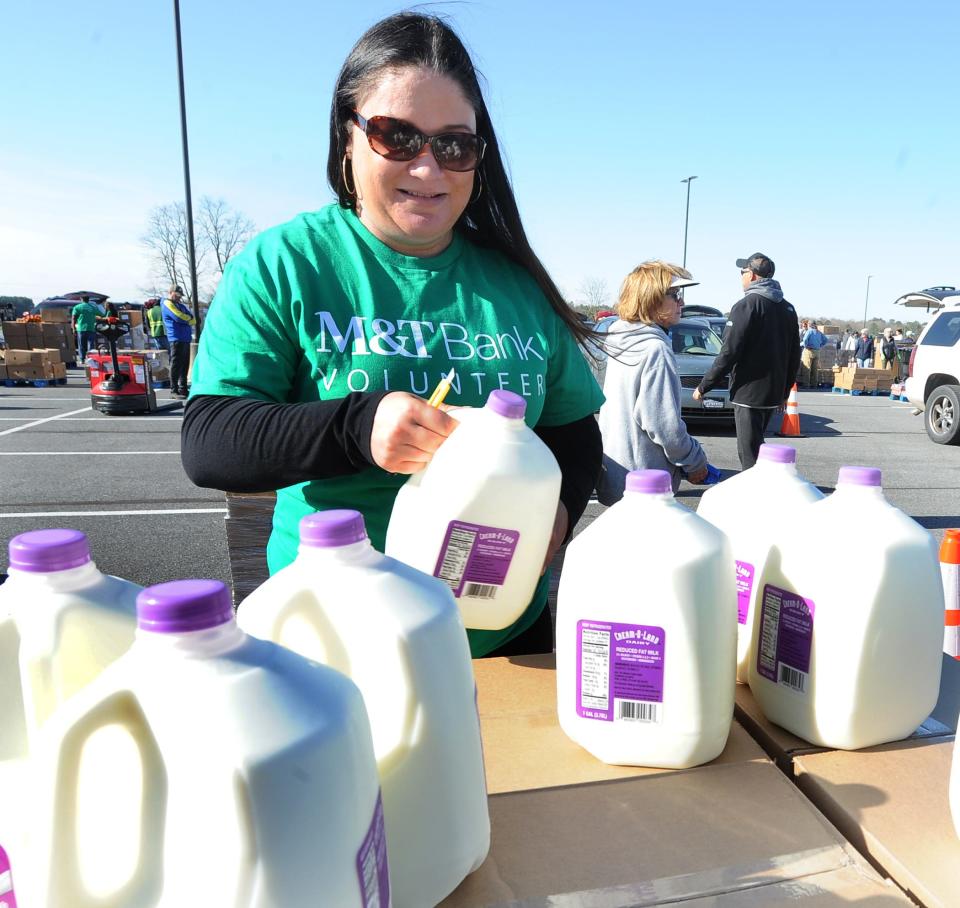 Courtney Rovillard, of Long Neck, hands out gallons of milk at the Food Bank of Delaware's drive-thru event held at Crossroad Community Church near Georgetown.