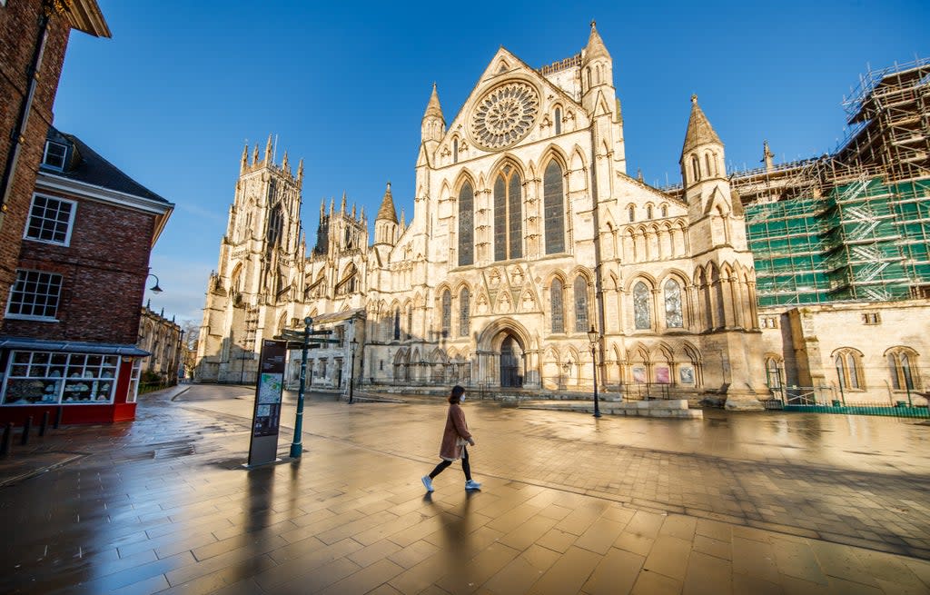 A woman walks past York Minster in Yorkshire (PA Archive)