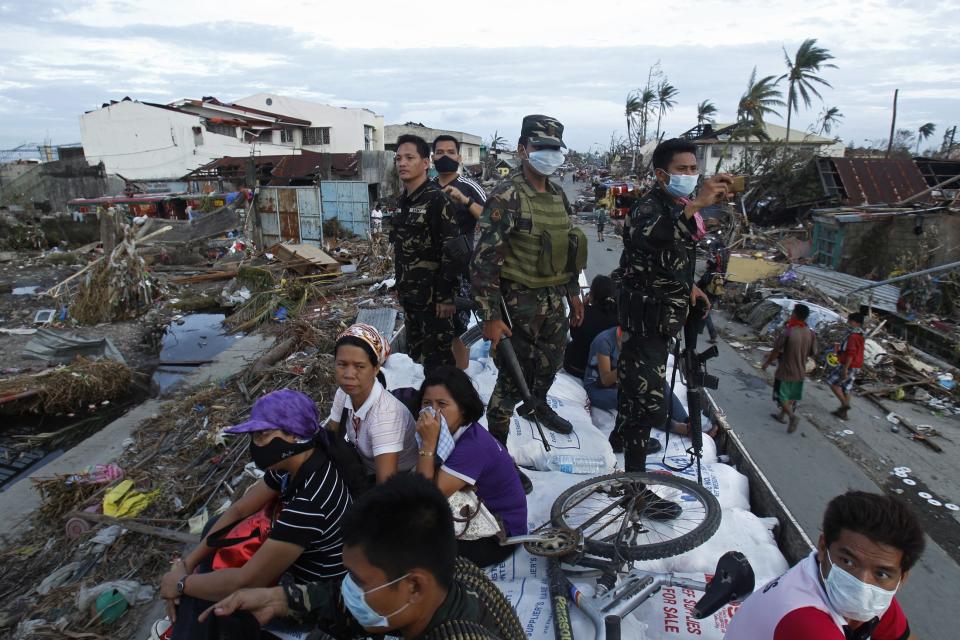 Soldiers and residents look at the devastation of the town from a military aid supplies distribution truck after the Super typhoon Haiyan battered Tacloban city