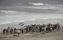 <p>Demonstrators march to meet Central American migrants traveling in a caravan for a gathering at the border on the beach where the border wall ends in the ocean, April 29, 2018, in San Diego. (Photo: Chris Carlson/AP) </p>