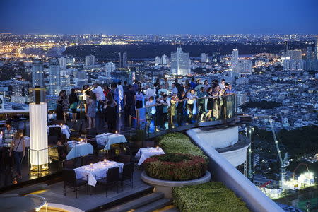 Visitors and tourists enjoy drinks and the view from a rooftop bar in central Bangkok May 20, 2015. REUTERS/Damir Sagolj