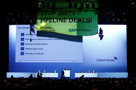 Chairman Urs Rohner and CEO Tidjane Thiam of Swiss bank Credit Suisse look up as activists of environmental group Greenpeace unveil a banner to protest against the financing of the Dakota-Access oil pipeline during the bank's annual shareholder meeting in Zurich, Switzerland April 28, 2017. REUTERS/Arnd Wiegmann