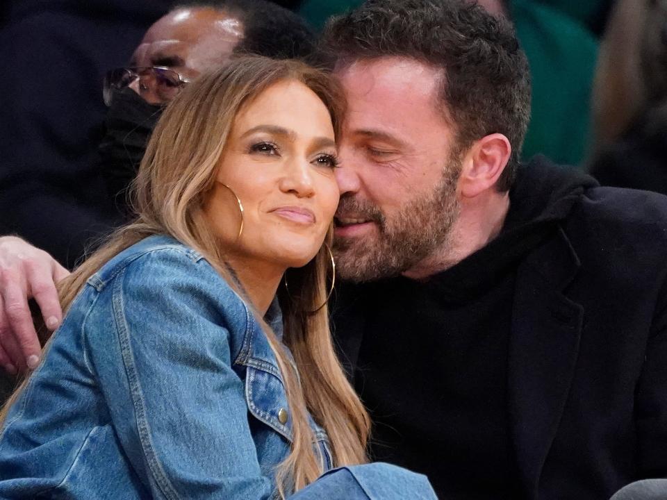 Jennifer Lopez and Ben Affleck sitting courtside at a baskeball game in December 2021.