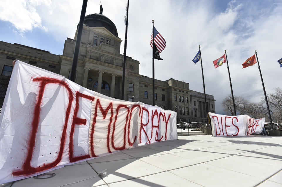 FILE - Demonstrators hold a sign that reads "Democracy Dies Here," on the steps of the Montana State Capitol, in Helena, Mont., Monday, April 24, 2023. A Montana state judge Wednesday, Sept. 27, 2023, has blocked enforcement of a law to ban gender-affirming medical care for minors. (Thom Bridge/Independent Record via AP)