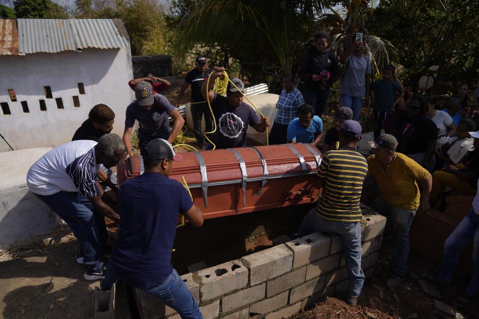 People carry the coffin of miner Santiago Mora during his burial at the cemetery in La Paragua, Bolivar state, Venezuela, Thursday, Feb. 22, 2024. The collapse of an illegally operated open-pit gold mine in central Venezuela killed at least 14 people and injured several more, state authorities said Wednesday, as some other officials reported an undetermined number of people could be trapped. (AP Photo/Ariana Cubillos)