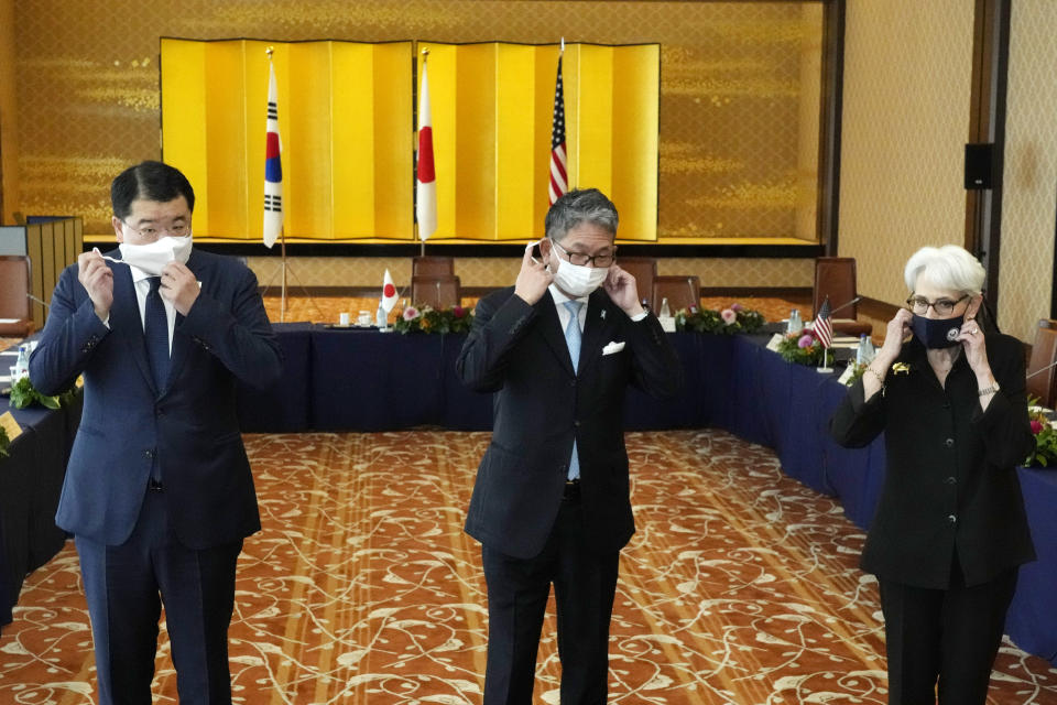 U.S. Deputy Secretary of State Wendy Sherman, right, South Korean First Vice Foreign Minister Choi Jong Kun, left, with Japanese Vice-Minister for Foreign Affairs Takeo Mori, center, take off their protective masks to pose for photographers prior to their trilateral meeting at the Iikura Guesthouse Wednesday, July 21, 2021, in Tokyo. (AP Photo/Eugene Hoshiko)