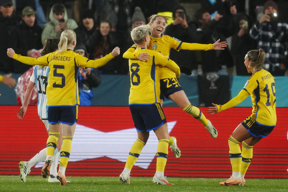 La sueca Elin Rubensson (arriba) celebra con sus compañeras de selección tras anotar un penal en el último partido del Grupo G del Mundial femenino contra Argentina, en Hamilton, Nueva Zelanda, el 2 de agosto de 2023. (AP Foto/Abbie Parr)