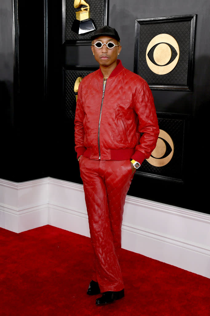 Pharrell Williams in red leather quilted suit with zippered jacket.