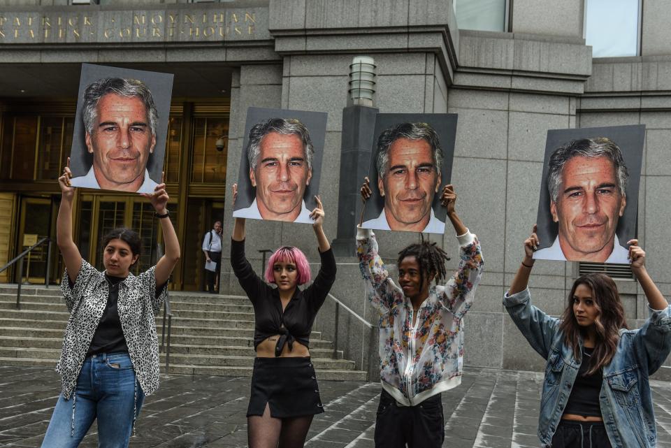 Protesters hold up photos of Jeffrey Epstein outside a courthouse in New York on July 8, 2019.