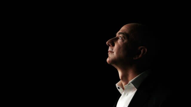 Jeff Bezos, CEO and founder of Amazon, is illuminated by a display screen at the introduction of the new Amazon Kindle Fire HD and Kindle Paperwhite in Santa Monica, Calif., Thursday, Sept. 6, 2012. (AP Photo/Reed Saxon)