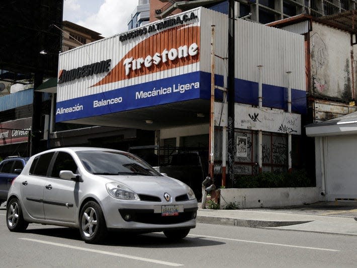 Commuters pass by the front of a Bridgestone Firestone tires store in Caracas, Venezuela November 5, 2016.  REUTERS/Marco Bello 