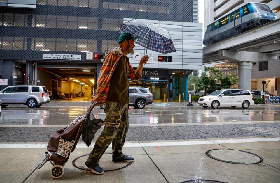 Jason Bryant, 51, of Miami, says, “It’s raining sideways” as he walks along S.E. 7th Street across from Brickell City Center in Miami on Wednesday, November 15, 2023. Bryant says he is homeless and living at a Chapman Partnership shelter.