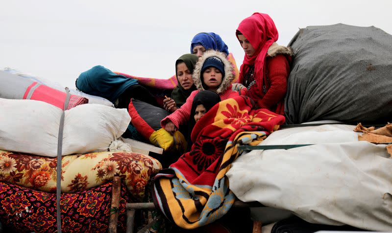 FILE PHOTO: Internally displaced Syrians from western Aleppo countryside, ride on a vehicle with belongings in Hazano near Idlib