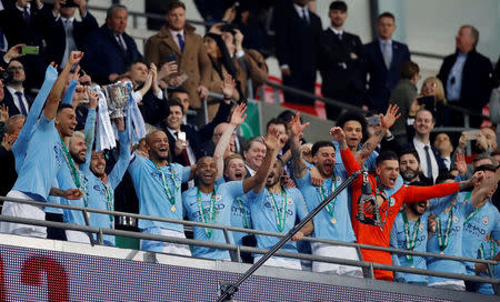 Soccer Football - Carabao Cup Final - Manchester City v Chelsea - Wembley Stadium, London, Britain - February 24, 2019 Manchester City's Vincent Kompany celebrates with the trophy and team mates after winning the penalty shootout Action Images via Reuters/Carl Recine