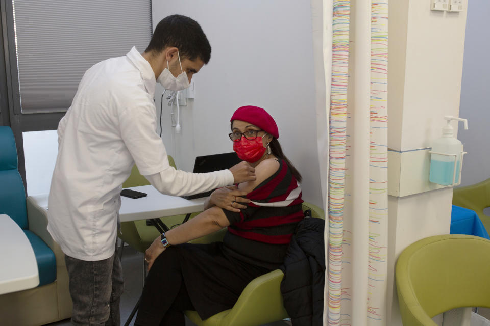 A nurse swabs a woman's arm before administering the coronavirus vaccine at a health center in Jerusalem, Wednesday, Dec. 30, 2020. (AP Photo/Maya Alleruzzo)