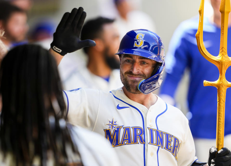 Seattle Mariners' Tom Murphy greets starting pitcher Luis Castillo in the dugout while holding a trident to celebrate his solo home run against the Tampa Bay Rays during the sixth inning of a baseball game, Sunday, July 2, 2023, in Seattle. (AP Photo/Lindsey Wasson)
