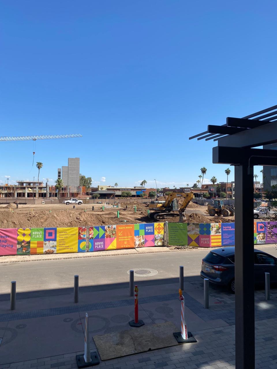 A photo taken in October 2023 shows the site where three Fox Restaurant Concepts restaurants will be built. Further east, a 330-unit apartment complex is under construction.