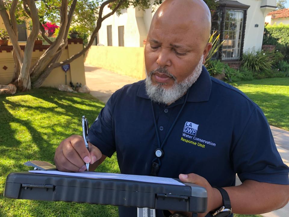 Lawrence Springer of the Los Angeles Department of Water and Power's conservation response unit writes down a home's information after identifying a wayward sprinkler system in violation of the agency's rules on water waste.