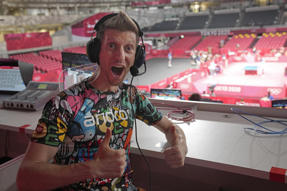 Adam Bobrow, lead commentator for the International Table Tennis Federation, poses for a photograph during the table tennis men's team semifinal between Germany and Japan at the 2020 Summer Olympics, Wednesday, Aug. 4, 2021, in Tokyo. Bobrow, the Voice of Table Tennis, possesses an arsenal of tricky spin shots, captured on YouTube and watched by millions, that can leave even good opponents gape-mouthed and then, as the wildness of what they’ve seen sinks in, delighted. What he really likes, though, is to travel the world as a sort of ambassador for the sport. (AP Photo/Kin Cheung)