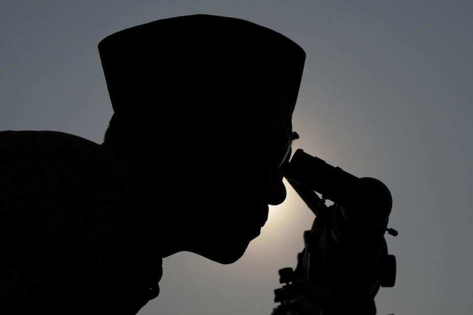 An official is silhouetted as he uses a telescope to scan the horizon for a crescent moon that will determine the beginning of the holy fasting month of Ramadan in Jakarta, Indonesia, Wednesday, March. 22, 2023. Millions of Muslims in Indonesia are gearing up to celebrate the holy month of Ramadan, which is expected to start on Thursday, with traditions and ceremonies across the world's most populous Muslim-majority country amid soaring food prices.(AP Photo/Achmad Ibrahim)