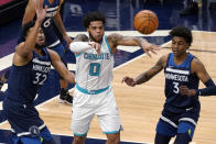 Charlotte Hornets' Miles Bridges (0) gets off a pass from between Minnesota Timberwolves' Karl-Anthony Towns (32) and Jaden McDaniels (3) during the first half of an NBA basketball game Wednesday, March 3, 2021, in Minneapolis. (AP Photo/Jim Mone)