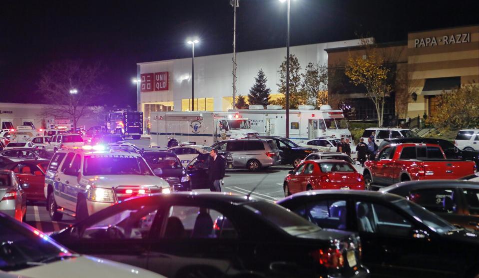 Vehicles belonging to the police, emergency services and shoppers fill the parking lot as the police respond to reports of gunshots at the Garden State Plaza mall in Paramus