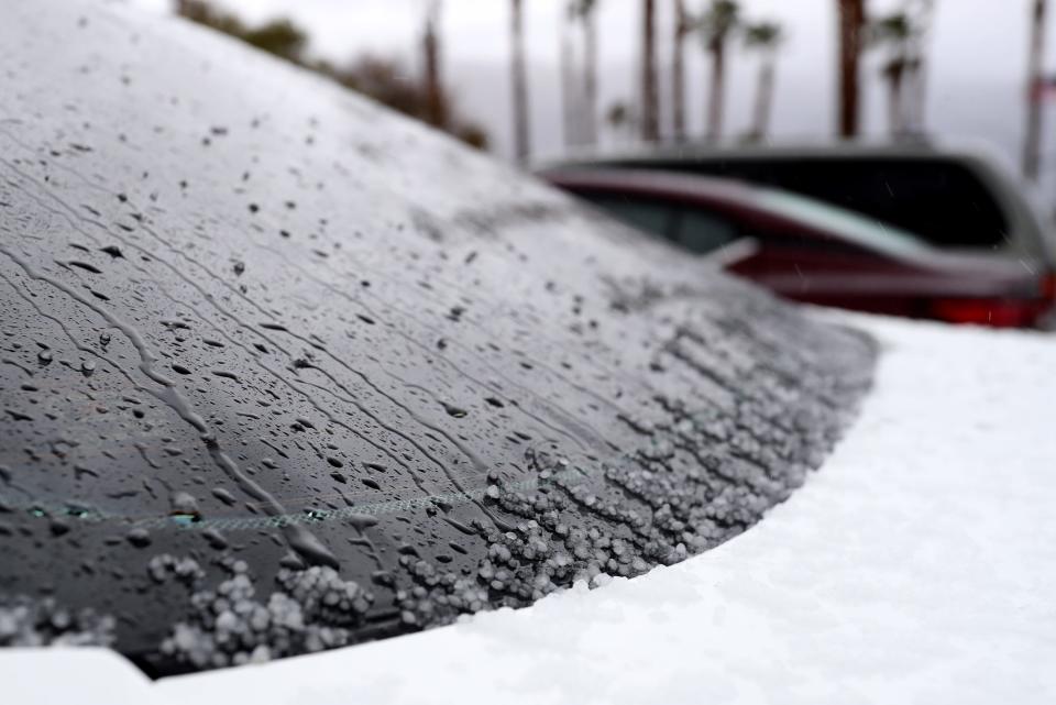 Hail accumulates on a car in Palm Springs, Calif., on March 1, 2023.