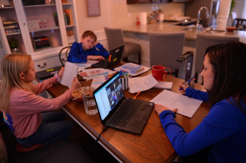 Marie Fox, right, an AP Biology teacher at Broome High School, teaches her students in a virtual e-learning class, from her home Wednesday morning, January 19, 2022. Her children, 5th grader C.J. and 3rd grader Ryann, left, study their lessons at the same time.