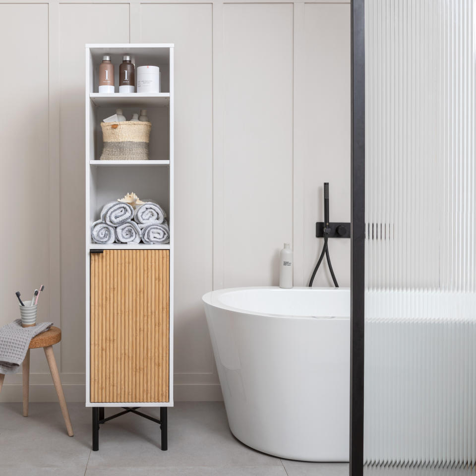 Bathroom with bathtub and storage units