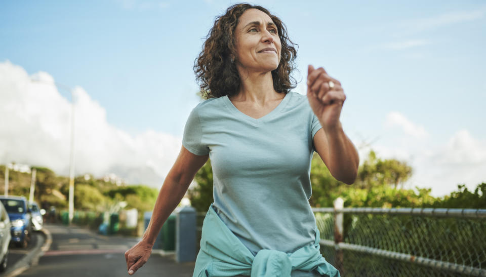 Woman smiling while taking a leisurely walk outdoors