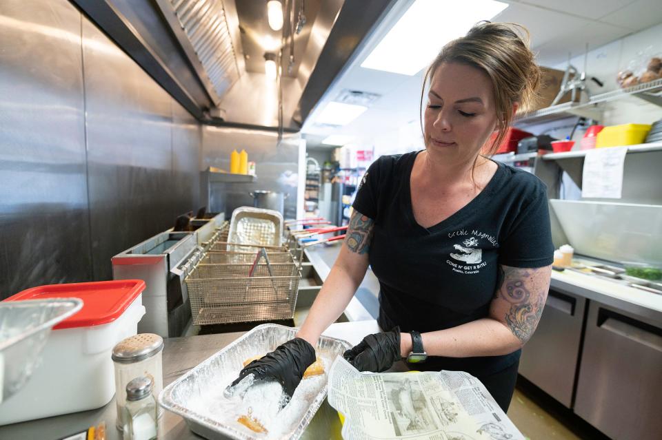 Amber Kliesen prepares an order of beignets in the kitchen of Lobos at Creole Magnolias, 2290 Rawlings Blvd., on Tuesday.