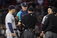 Seattle Mariners manager Scott Servais talks with umpires during during a pitching change in the sixth inning of the team's baseball game against the Boston Red Sox at Fenway Park, Thursday, May 19, 2022, in Boston. (AP Photo/Charles Krupa)