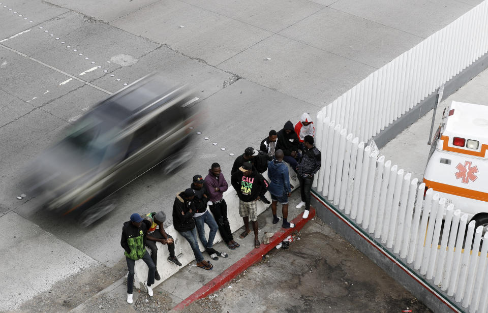 FILE - In this Tuesday, July 16, 2019, file photo, people wait to apply for asylum in the United States along the border in Tijuana, Mexico. In its efforts to remake the U.S. immigration system, the Trump administration has often stumbled over an obscure law that governs how administrative policies are made. Its latest test is a mammoth proposal to severely limit access to asylum, which invited nearly 80,000 public comments before the Wednesday, July 15, 2020, deadline to offer feedback. (AP Photo/Gregory Bull, File)