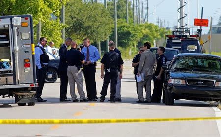 Fort Myers police officers confer next to Club Blu after a shooting attack in Fort Myers, Florida, U.S., July 25, 2016. REUTERS/Joe Skipper