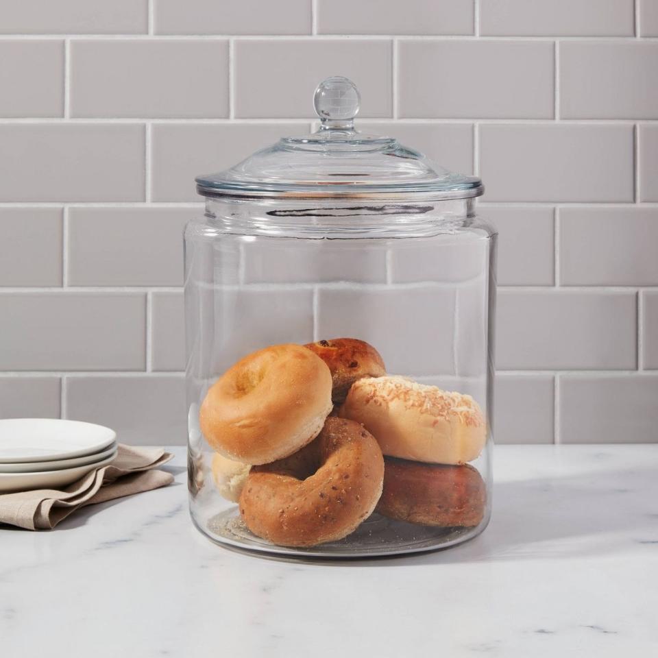 The jar on a countertop with bagels inside