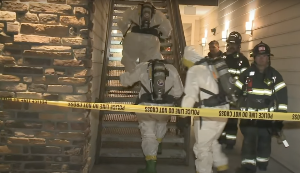 Police in hazmat suits and firefighters at a crime scene at an apartment block in Colorado.